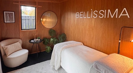 Cozy relaxation area at Bellissima Beauty, Waikanae, Wellington, NZ with plush chair and soft lighting.
