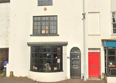 Front exterior of Pure Glow Clinic in Worthing, England, GB with large black windows and inviting entrance.