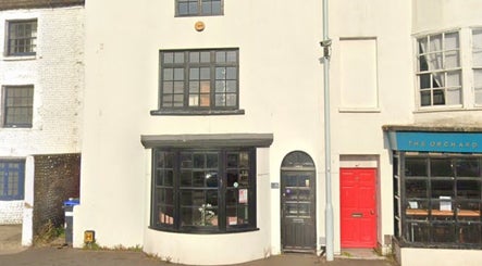 Front exterior of Pure Glow Clinic in Worthing, England, GB with large black windows and inviting entrance.