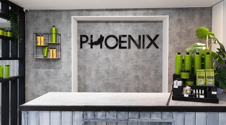 Reception desk at Phoenix Hair & Beauty in Wigan, England, GB, showcasing hair products on sleek shelves.