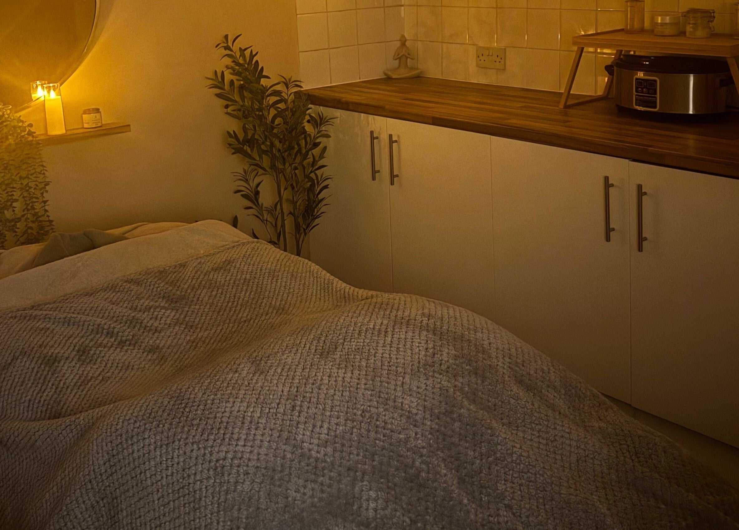 Cozy spa room at Simply Beauty Norwich, Norwich, England, GB with candles and a massage table.