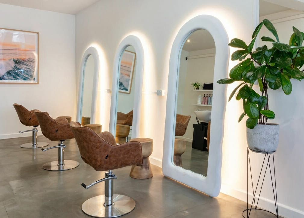 Sleek interior of That Girl Studio in St Kilda, Melbourne, featuring stylish chairs and mirrors.