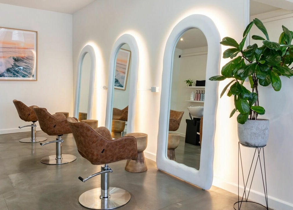 Sleek interior of That Girl Studio in St Kilda, Melbourne, featuring stylish chairs and mirrors.