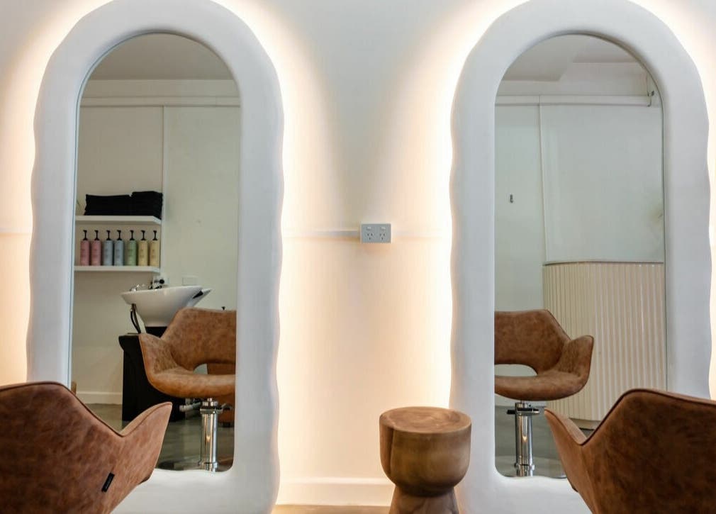 Chic salon at That Girl Studio in St Kilda, Melbourne, with stylish chairs and illuminated mirrors.