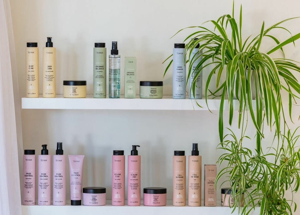 Skincare products on a white shelf with green plants at That Girl Studio, St Kilda, Melbourne, Victoria, AU.