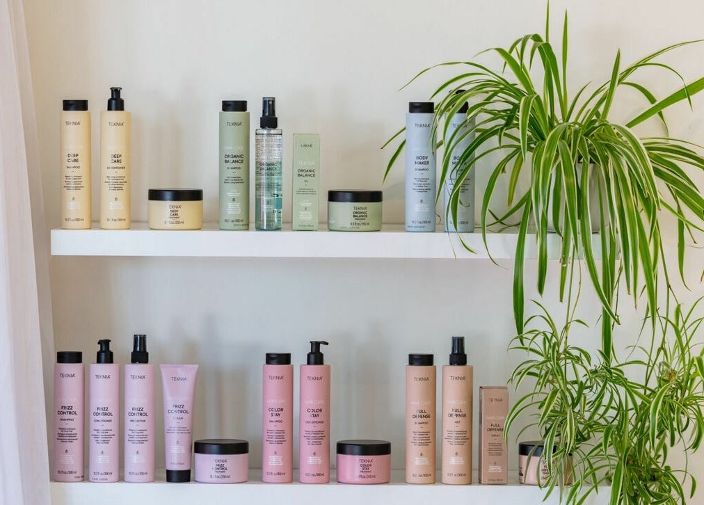 Skincare products on a white shelf with green plants at That Girl Studio, St Kilda, Melbourne, Victoria, AU.