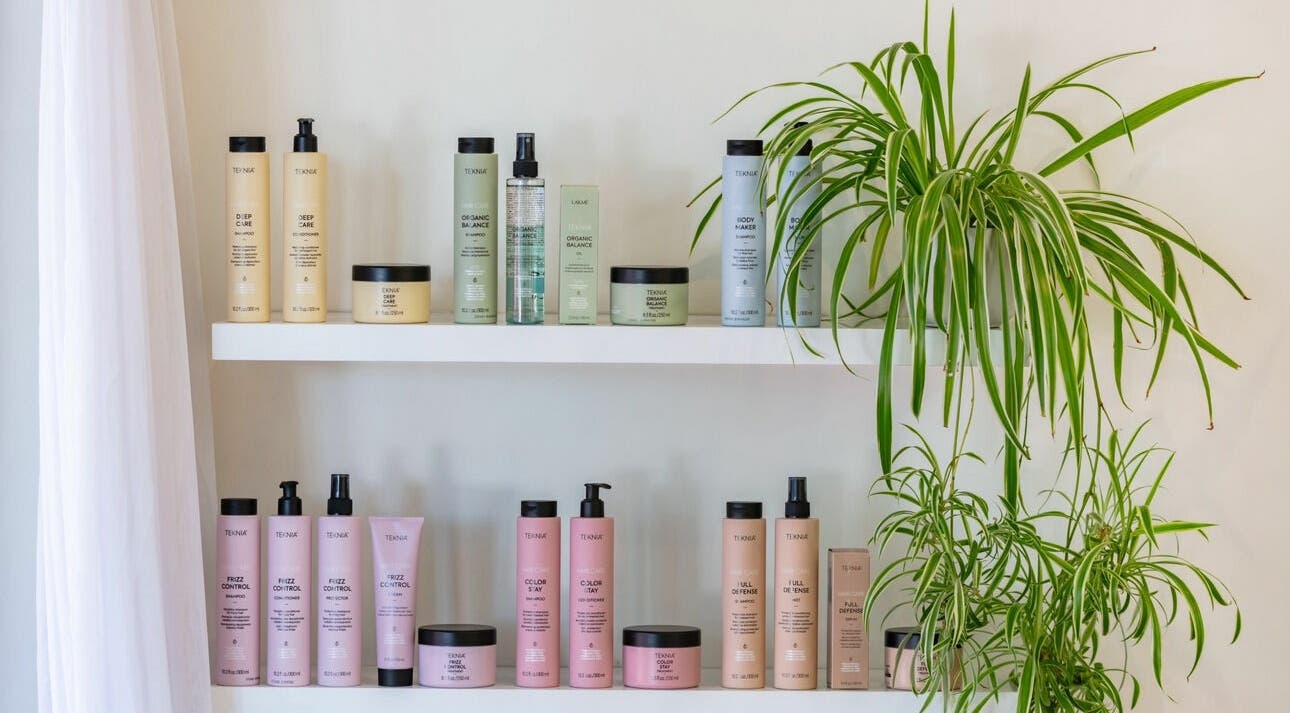 Skincare products on a white shelf with green plants at That Girl Studio, St Kilda, Melbourne, Victoria, AU.