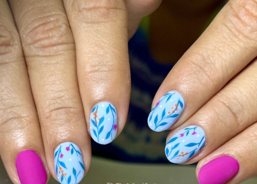 Manicura colorida con diseño tropical en DR Nail Studio, Heredia, Heredia, CR, destacando arte vibrante.
