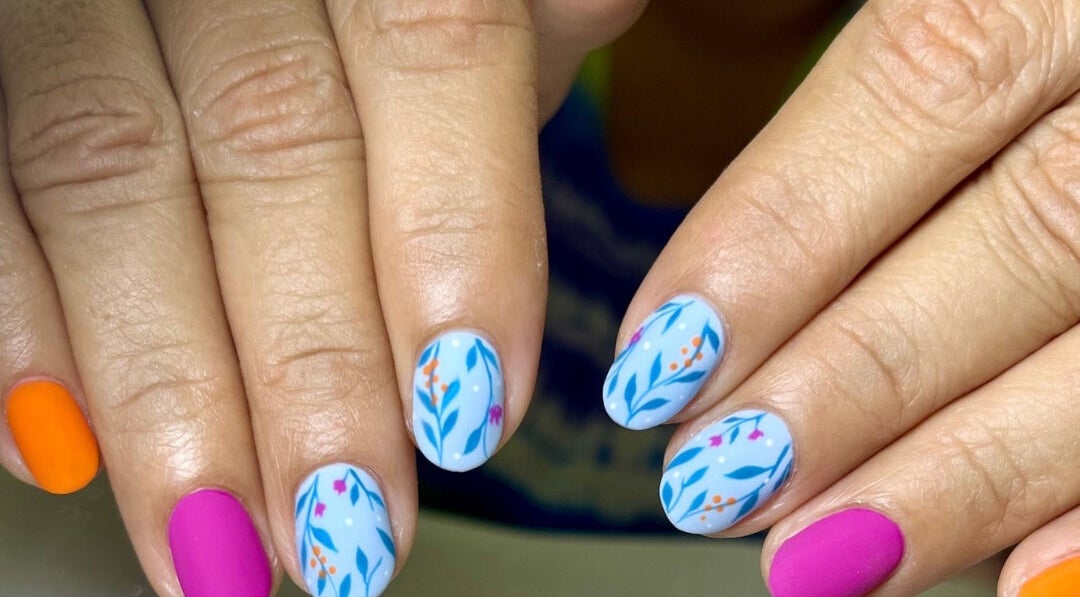 Manicura colorida con diseño tropical en DR Nail Studio, Heredia, Heredia, CR, destacando arte vibrante.