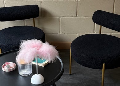 Stylish seating area at Aesthetic Atelier, Crawley, England, GB, featuring black chairs and a chic round table.