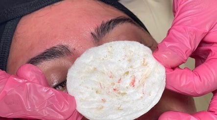 Skincare treatment at Glowberry, Romford, England, GB with pink gloves holding a cotton pad.