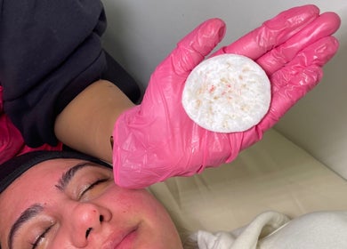 Glowberry facial with pink-gloved hand at Romford, England, GB enhancing skin wellness.