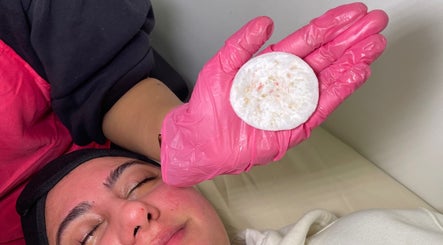 Glowberry facial with pink-gloved hand at Romford, England, GB enhancing skin wellness.