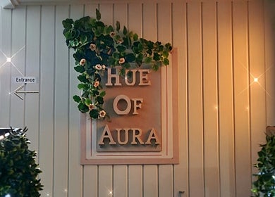 Entrance to Hue of Aura in Timaru, Canterbury, NZ, adorned with green foliage and elegant lighting.