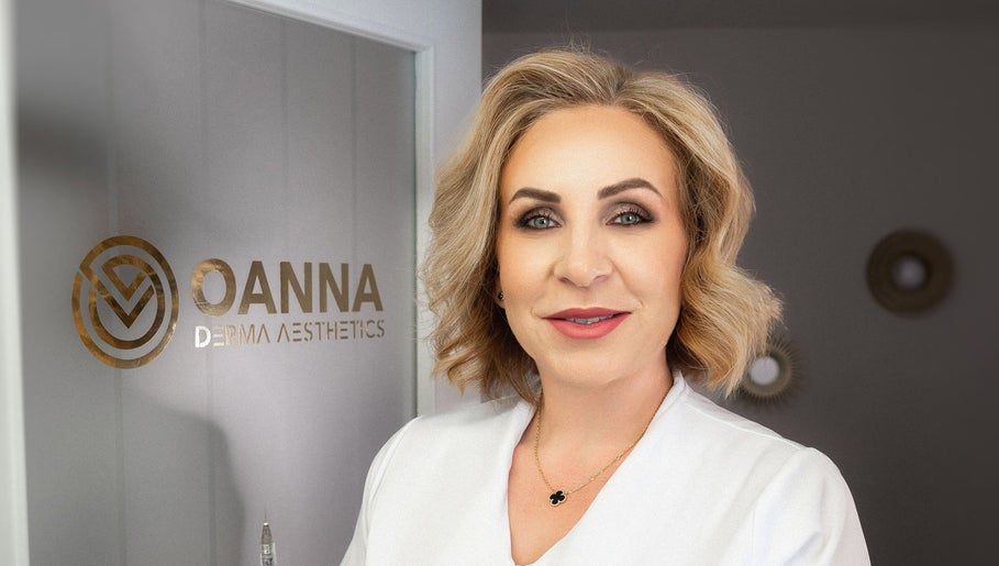Professional at Oanna Aesthetics in Corby, England, GB standing by the logo displaying expert skincare services.