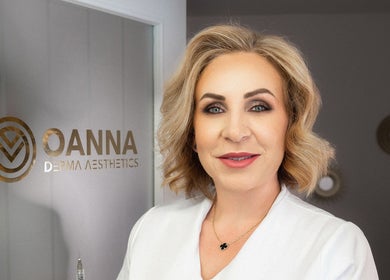 Professional at Oanna Aesthetics in Corby, England, GB standing by the logo displaying expert skincare services.