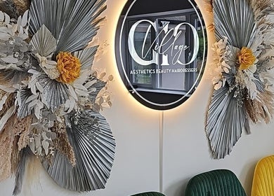 Elegant floral display at Oanna Aesthetics, Corby, England, GB with vibrant seating and a stylish illuminated sign.