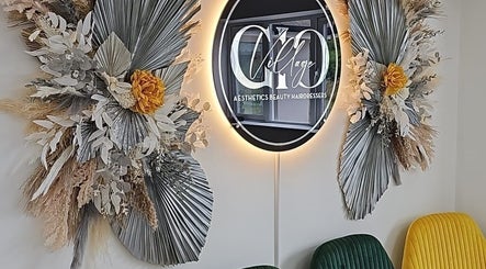 Elegant floral display at Oanna Aesthetics, Corby, England, GB with vibrant seating and a stylish illuminated sign.