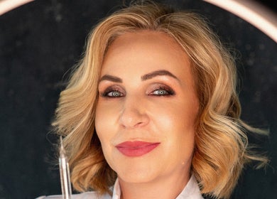 Smiling professional at Oanna Aesthetics, Corby, England, GB, showcasing beauty expertise.