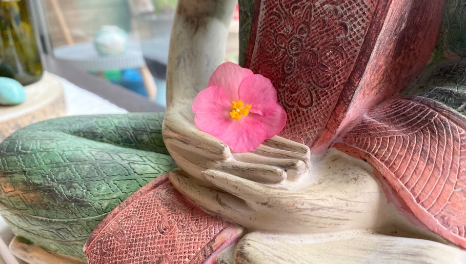Close-up of a Buddha statue with pink flower at Soulful Therapy, Amsterdam, Noord-Holland, NL.