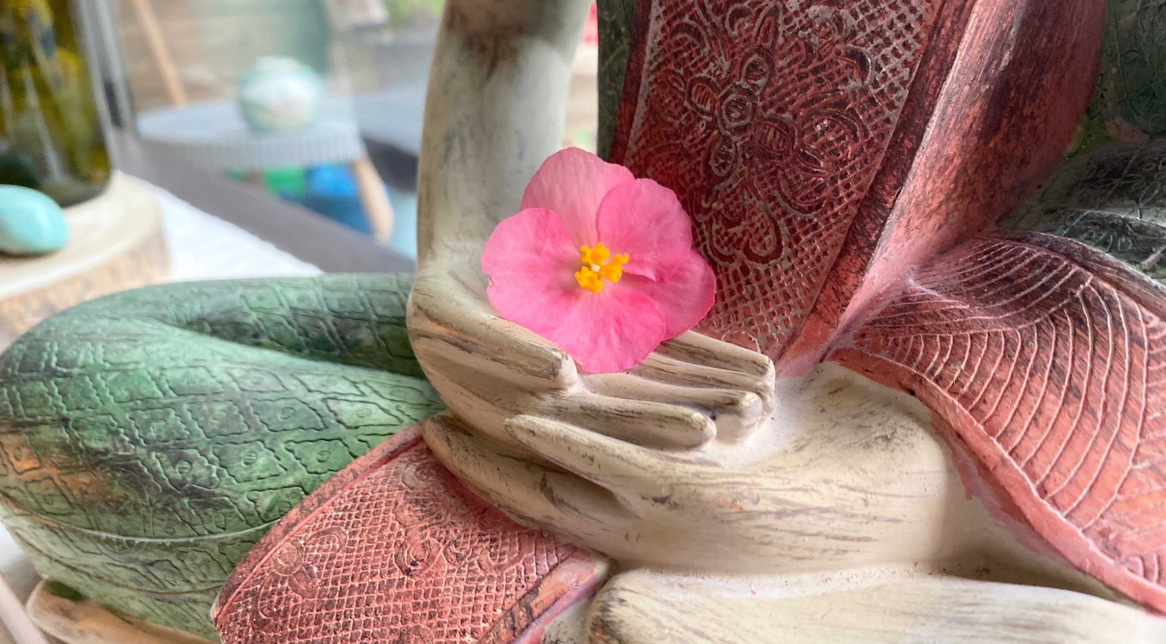 Close-up of a Buddha statue with pink flower at Soulful Therapy, Amsterdam, Noord-Holland, NL.