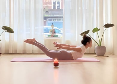 Woman practicing yoga with a candlelit ambiance at Soulful Therapy, Amsterdam, Noord-Holland, NL.