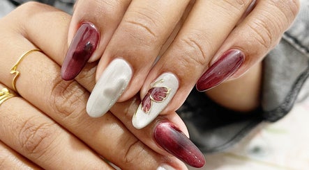 Elegant nail art design at MK Studio Kendari, Sulawesi Tenggara, ID featuring maroon and silver accents.