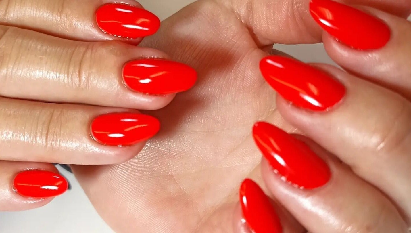 Vibrant red manicure at Tranquility C Salon, Krugersdorp, Gauteng, ZA showcasing elegant nail art.