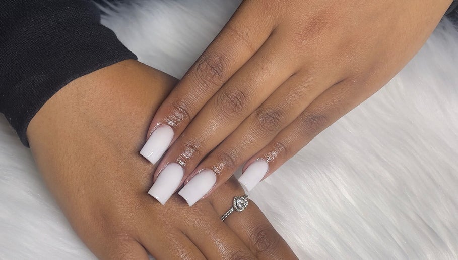 Elegant manicured hands from Trending UK Nails, London, England, GB on soft white fabric.
