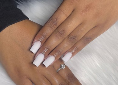 Elegant manicured hands from Trending UK Nails, London, England, GB on soft white fabric.