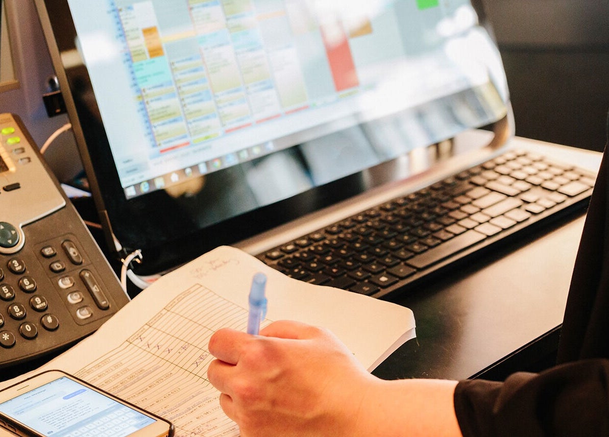 Staff managing appointments at Hair 'n Balance Studio, Paramaribo, SR on a computer.