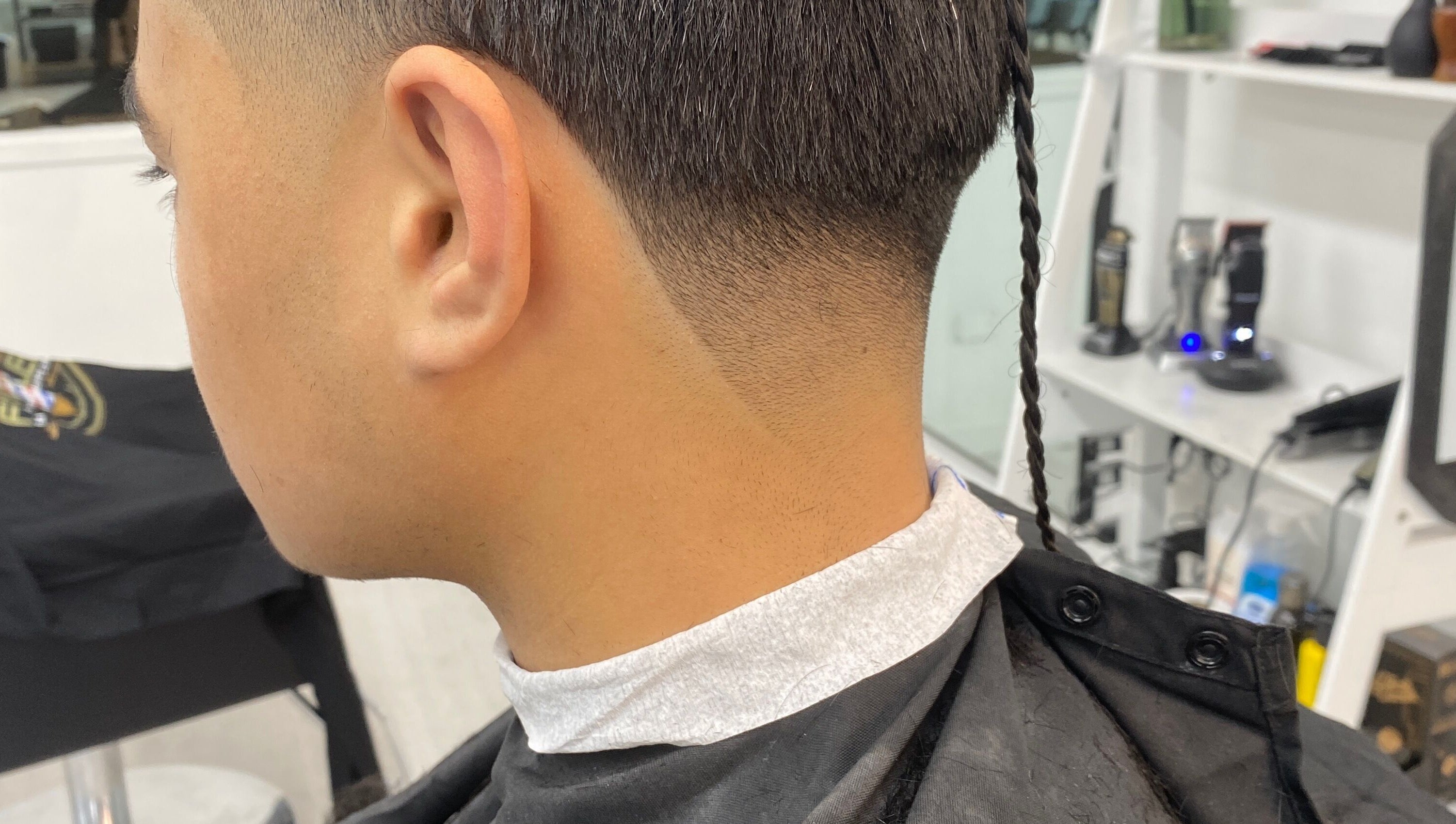 Close-up of a stylish fade haircut with a braided tail at Tapslab, Tokoroa, Waikato, NZ.