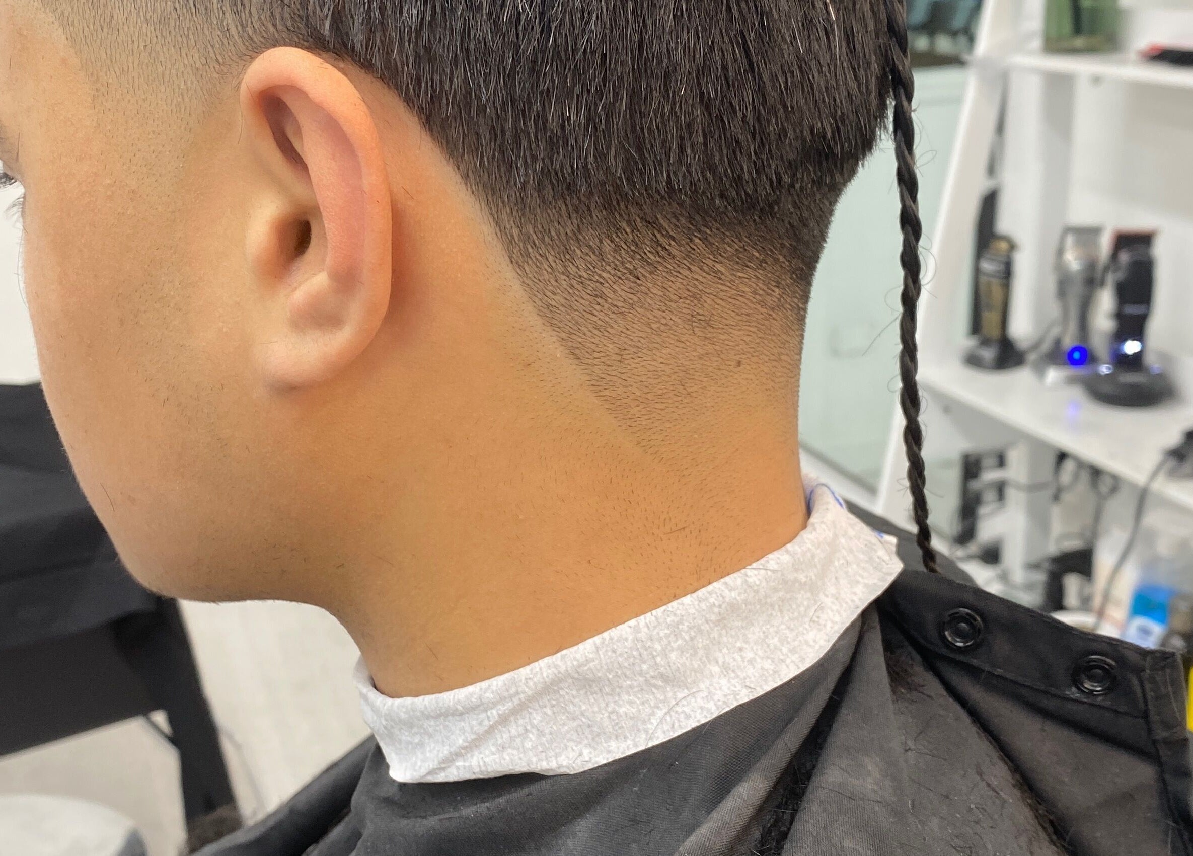 Close-up of a stylish fade haircut with a braided tail at Tapslab, Tokoroa, Waikato, NZ.