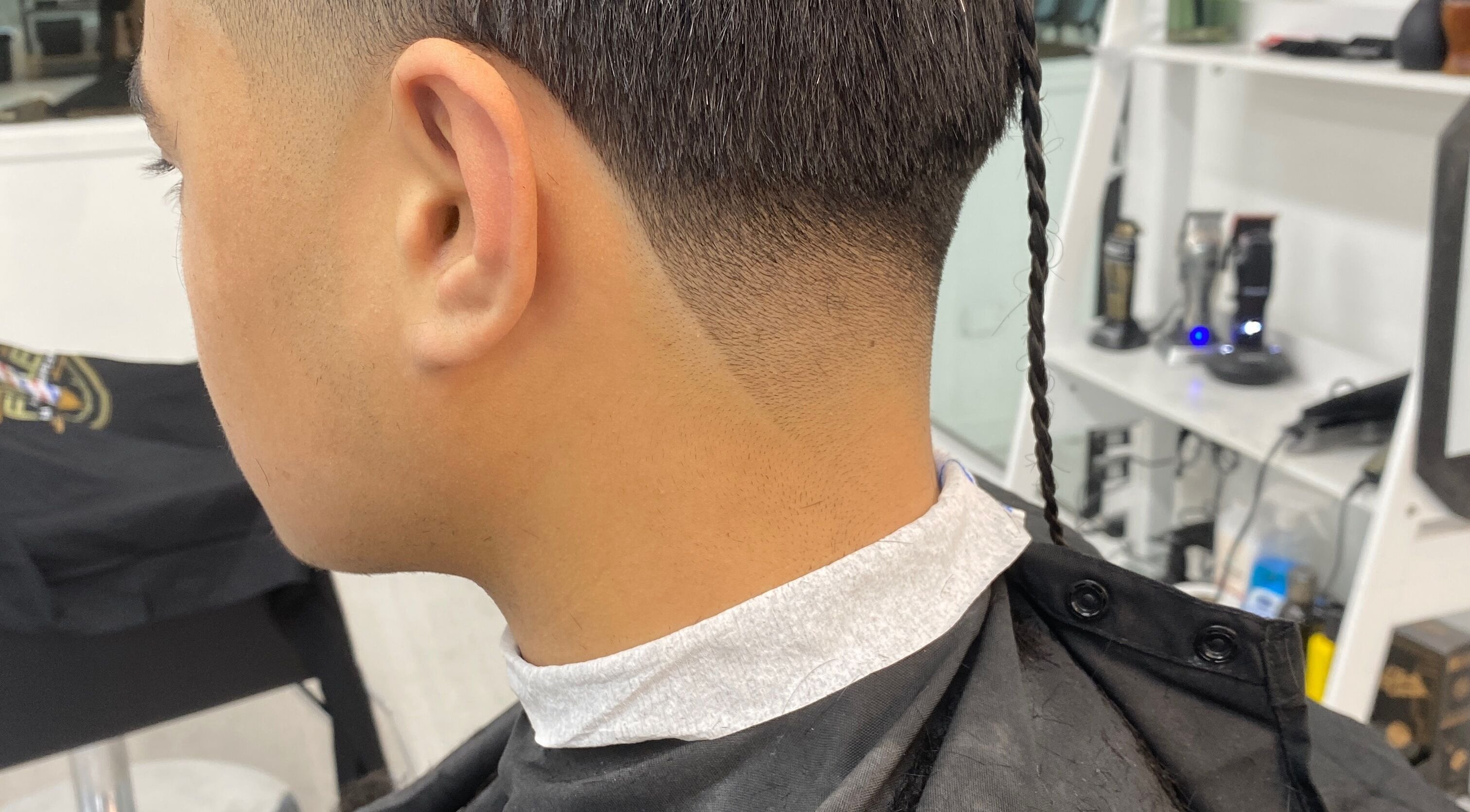 Close-up of a stylish fade haircut with a braided tail at Tapslab, Tokoroa, Waikato, NZ.
