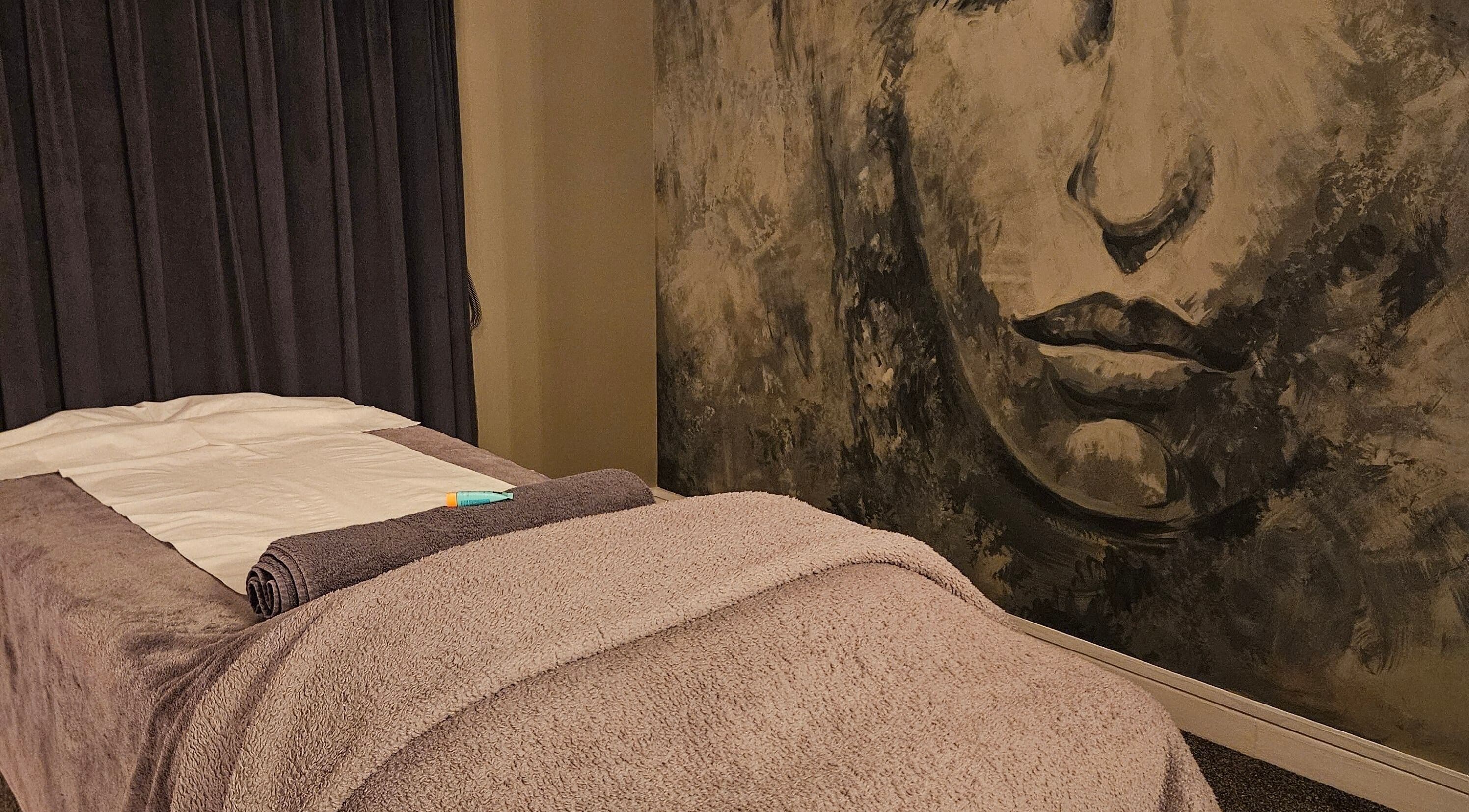 Relaxing massage room at Home Holistic in Dublin, County Dublin, IE with calming artwork and a prepared table.