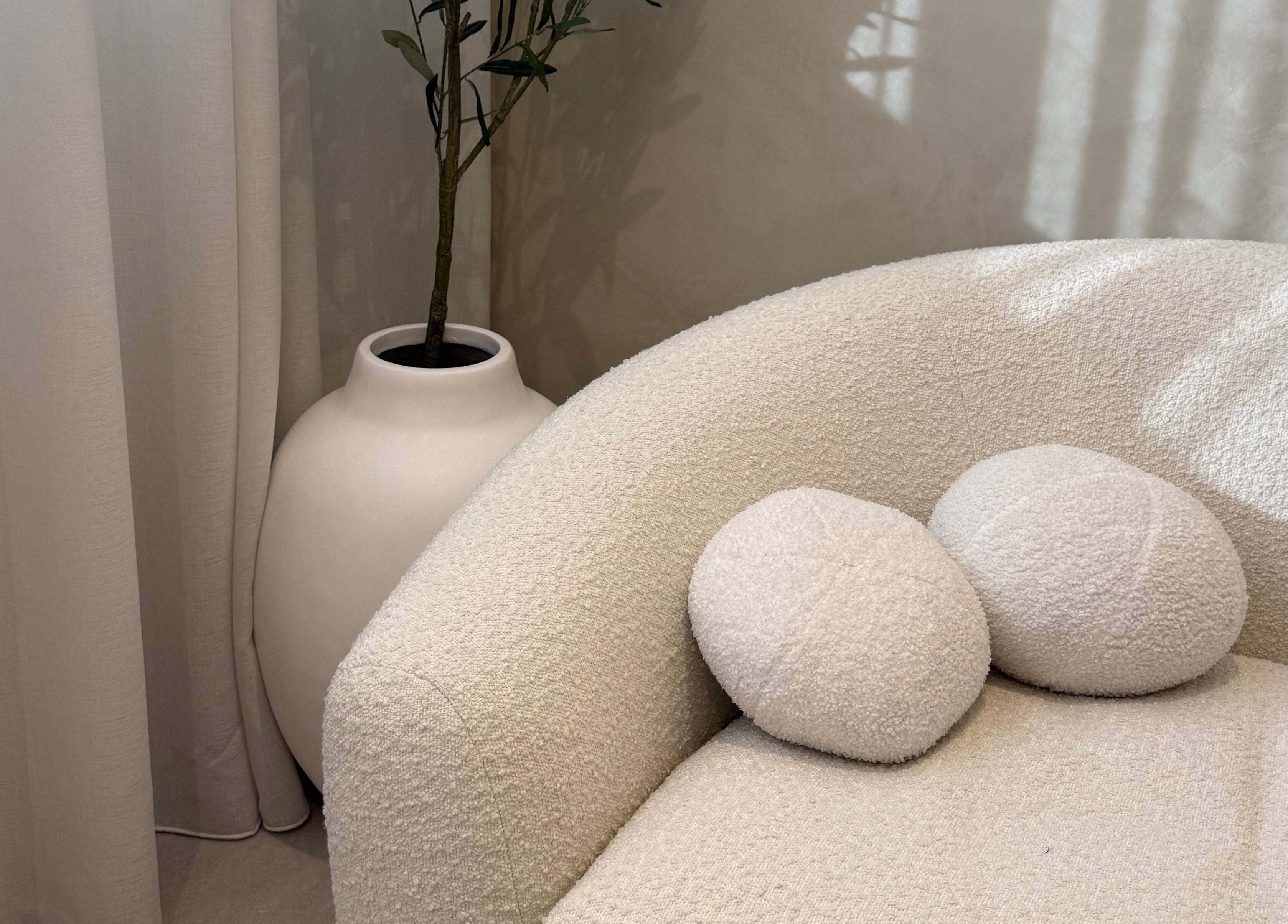 Cozy white sofa with pillows at EMBER Aesthetics, Mosman, New South Wales, AU, offering relaxing ambiance.