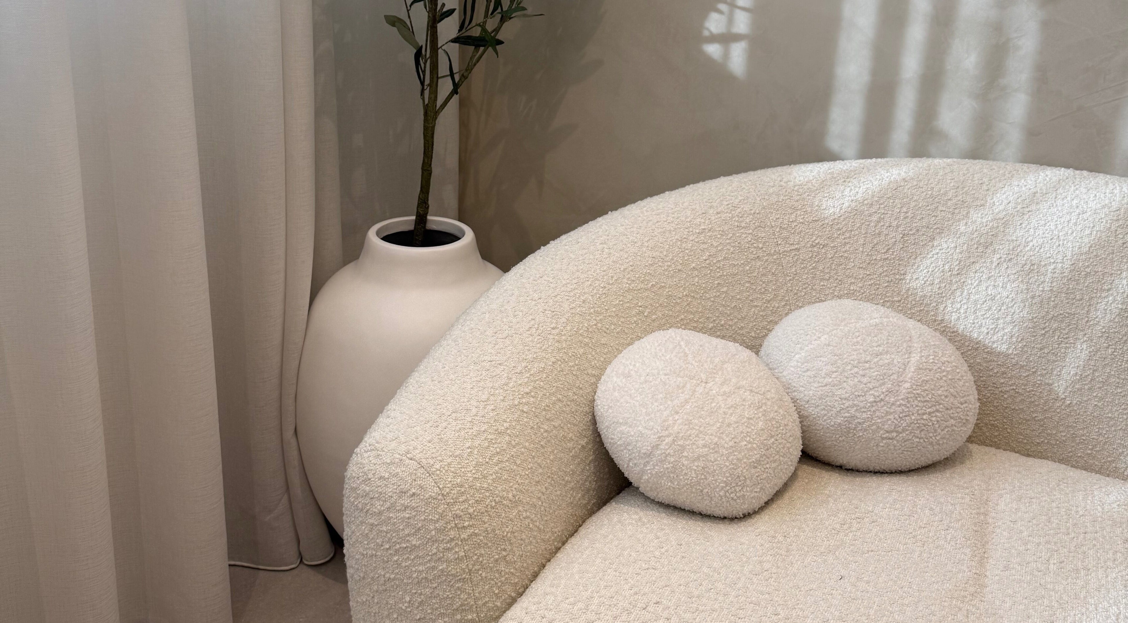 Cozy white sofa with pillows at EMBER Aesthetics, Mosman, New South Wales, AU, offering relaxing ambiance.