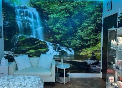 Relaxing treatment room at Refreshed Looks Aesthetics, Tucson, Arizona, US, with serene waterfall mural.