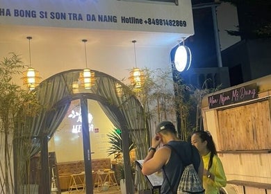 Entrance of Lee Spa & Massage, Đà Nẵng, beautifully lit at night with lush plants and modern decor.