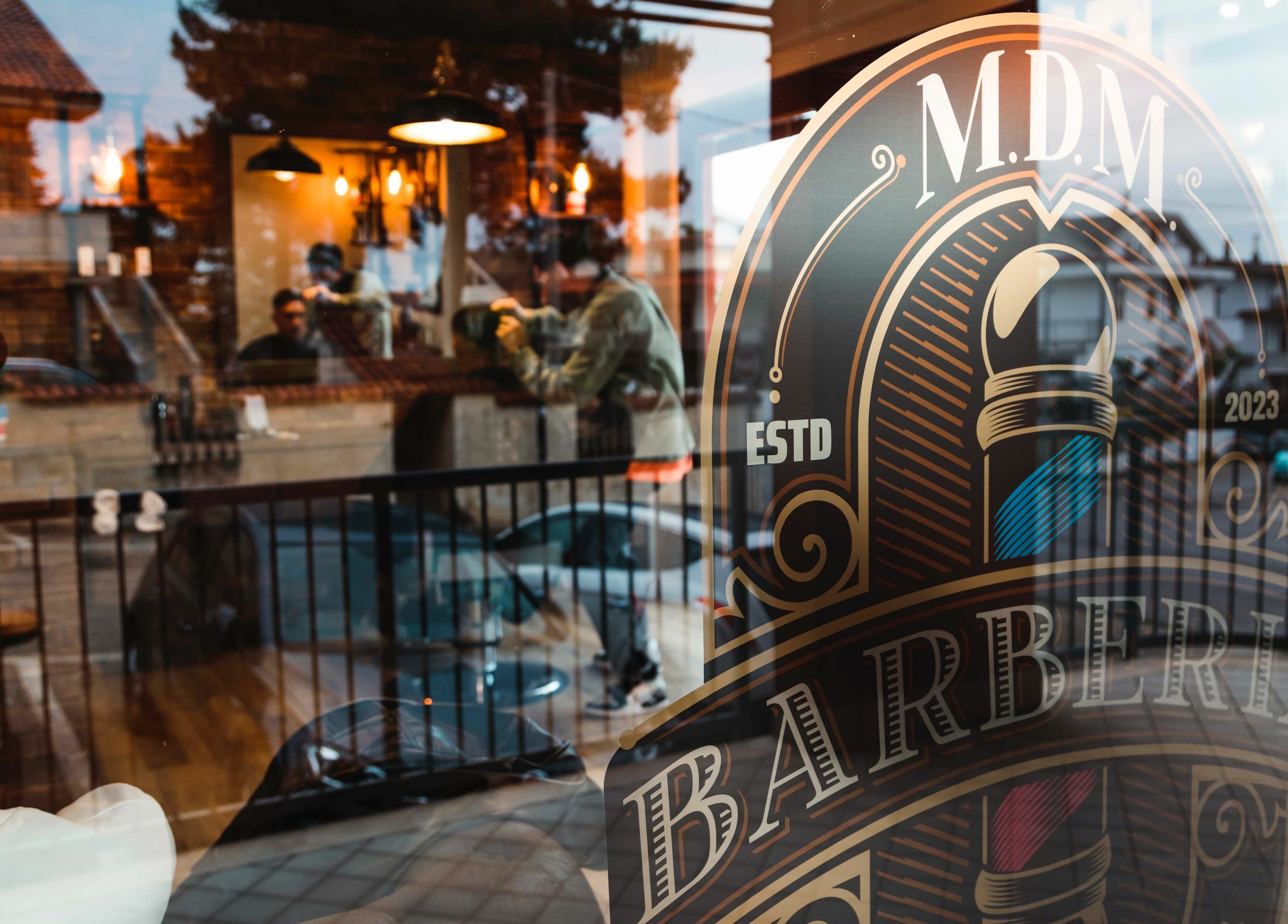 Vista della vetrina di MDM Barberia ad Abruzzo, IT riflette l'interno accogliente.