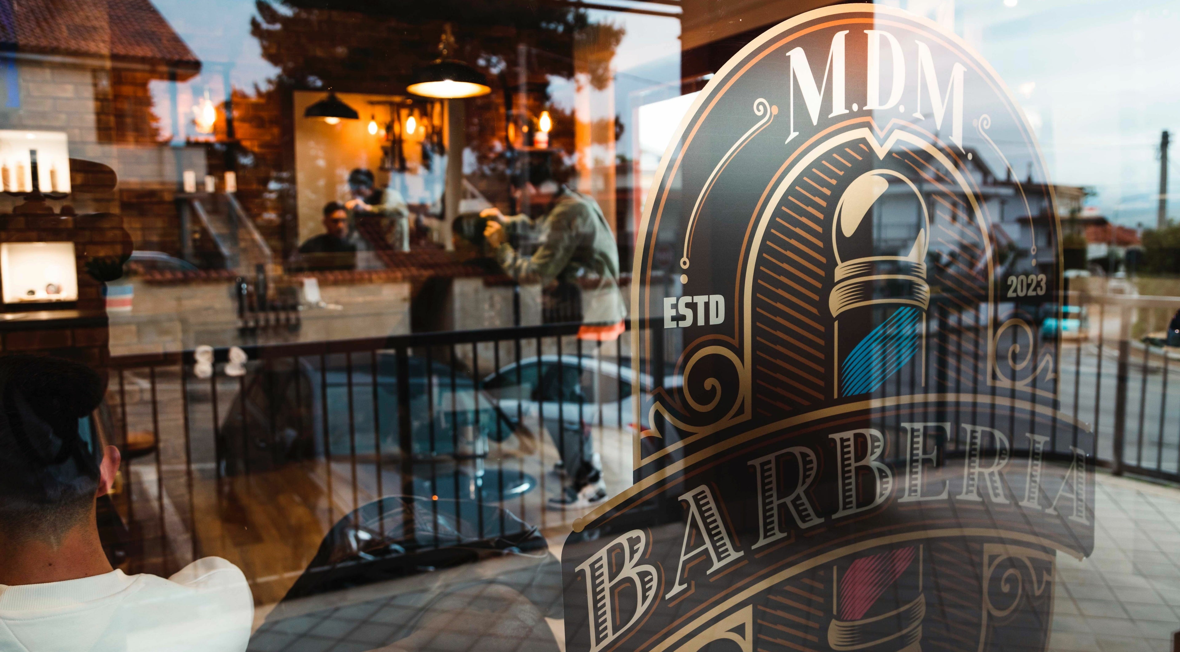 Vista della vetrina di MDM Barberia ad Abruzzo, IT riflette l'interno accogliente.