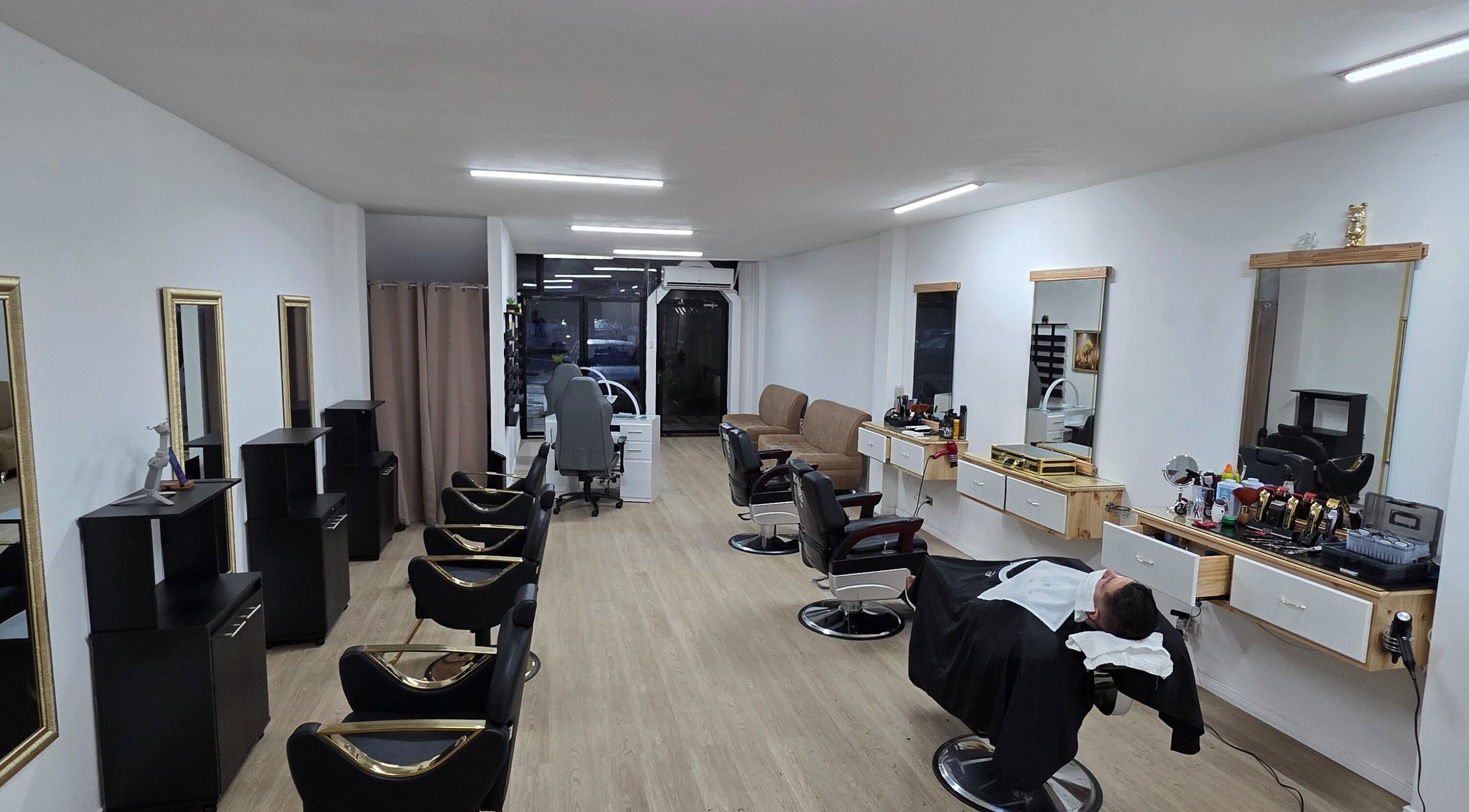Interior moderno de Golden Barbershop en Santa Ana, San José, CR, con sillas y espejos elegantes.