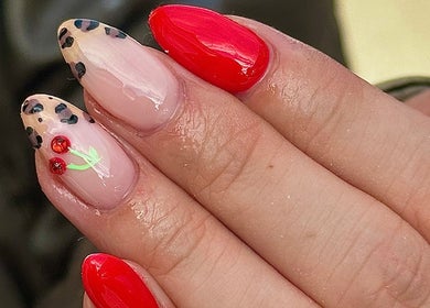 Stylish nail art in red and leopard print at Nail Luxe, Nantwich, England, GB.