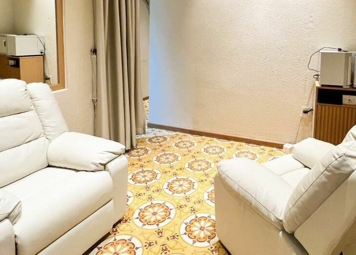 Relaxing seating area in Gemini Japanese Hair Salon, Hồ Chí Minh, Hồ Chí Minh, VN with plush white chairs.