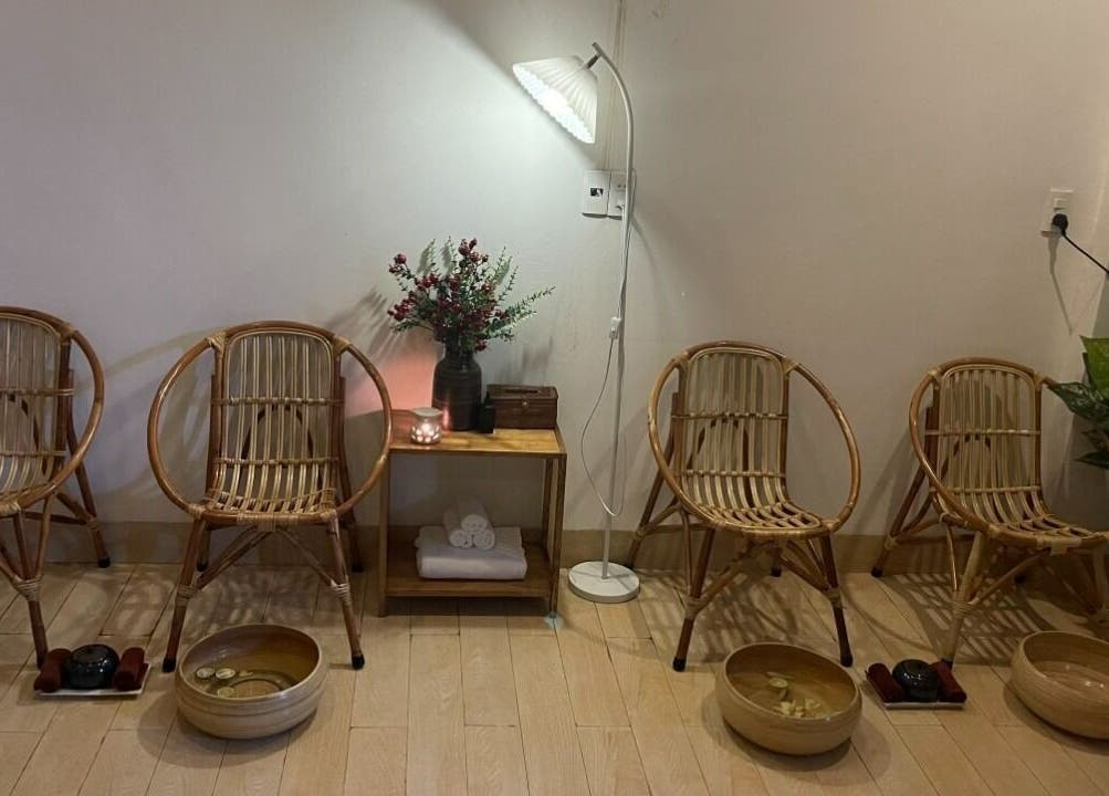 Relaxation area at Trees Spa Da Nang, Đà Nẵng, VN, showcasing bamboo chairs and footbaths for spa guests.