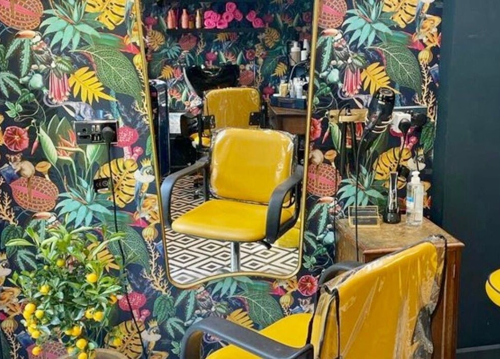 Colorful corner at Hush Secret Salon, Bristol, United Kingdom, GB with a yellow chair and tropical decor.