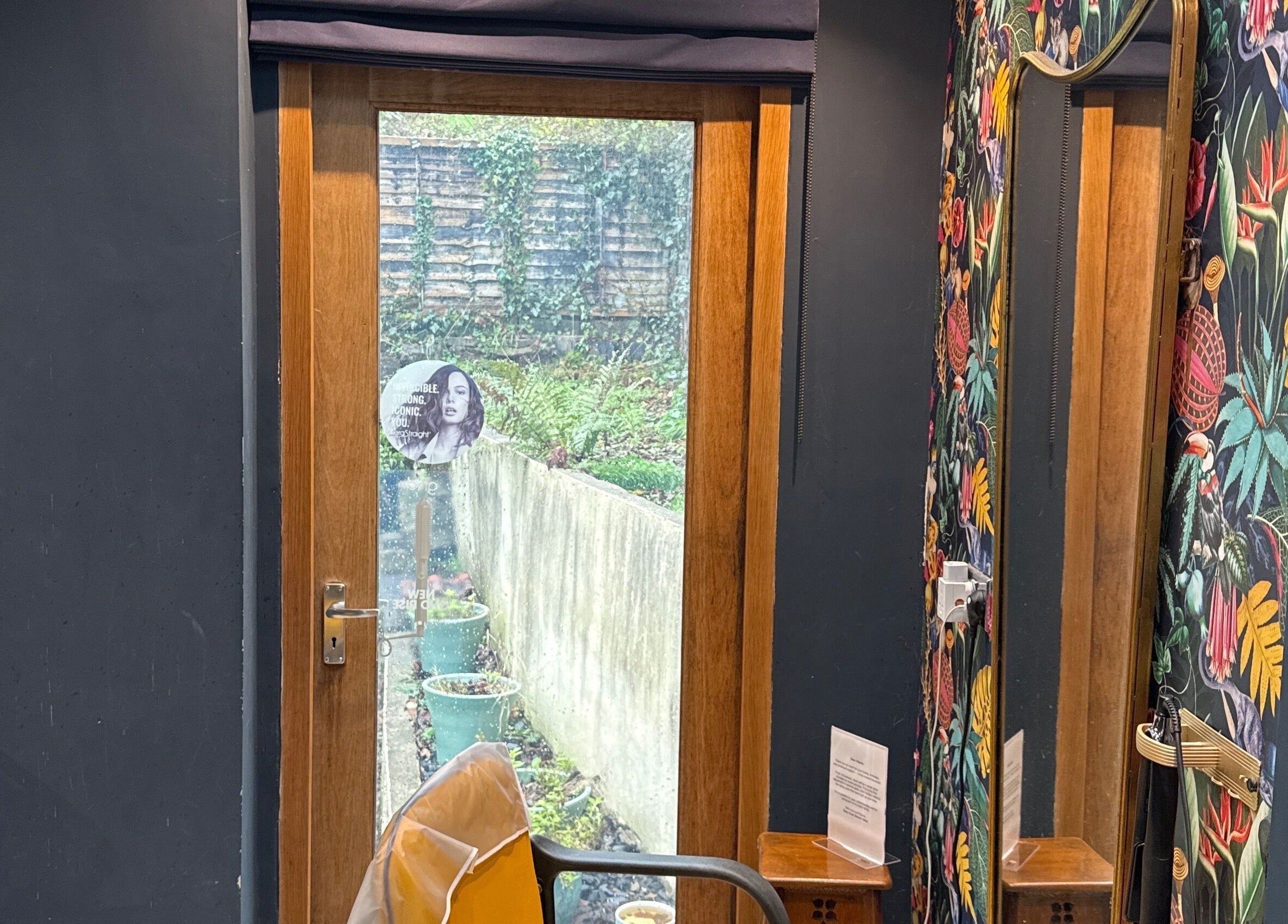 Chic interior of Hush Secret Salon, Bristol, United Kingdom, GB with vibrant wall decor and garden view.