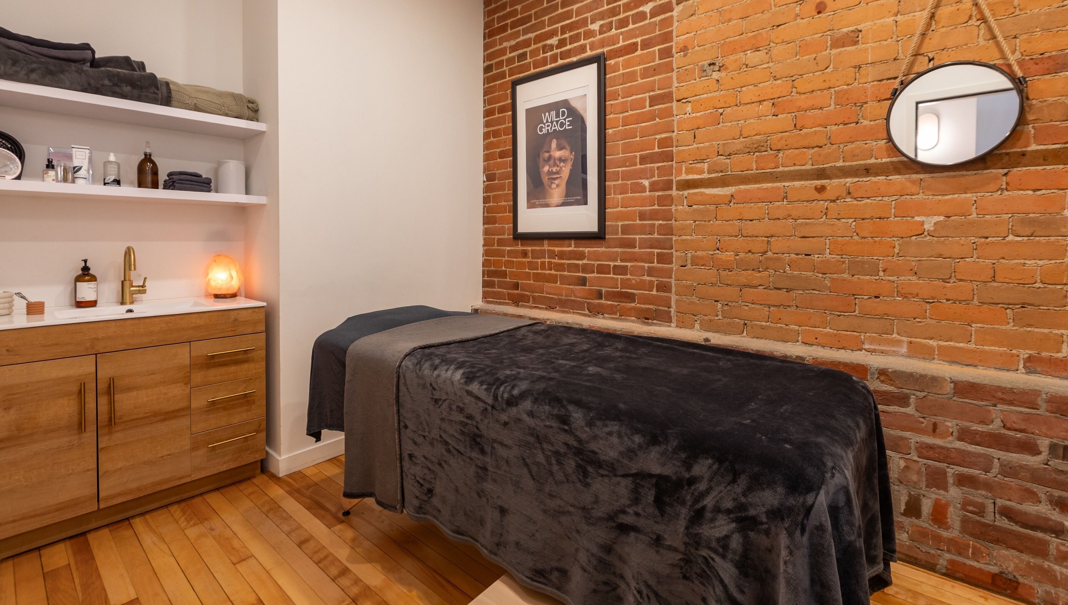 Salle de soins accueillante à La Loge Soins & Esthétique, Montréal, Québec, CA, avec décoration en briques.