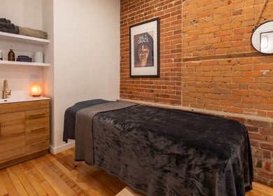 Salle de soins accueillante à La Loge Soins & Esthétique, Montréal, Québec, CA, avec décoration en briques.