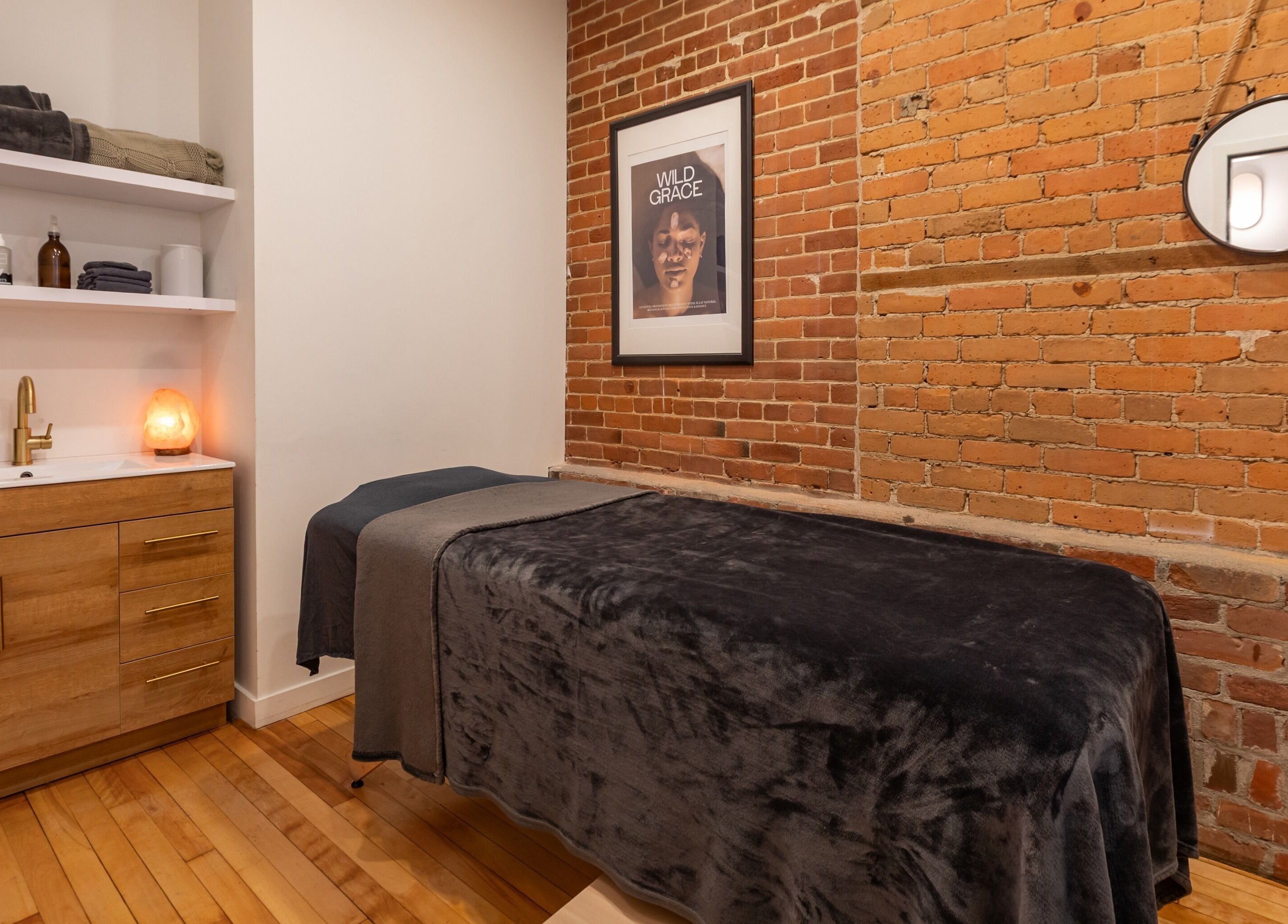 Salle de soins accueillante à La Loge Soins & Esthétique, Montréal, Québec, CA, avec décoration en briques.